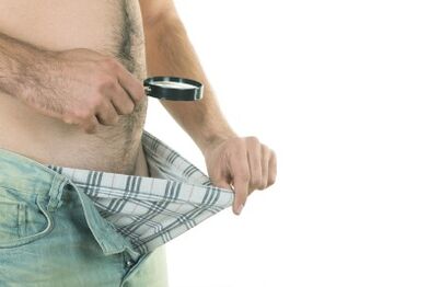 Muž se dívá na svůj penis a chce zvětšit jeho velikost
